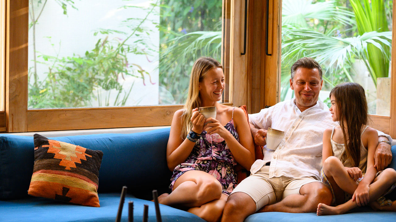 Two daughter is having a talk to their father on the sofa